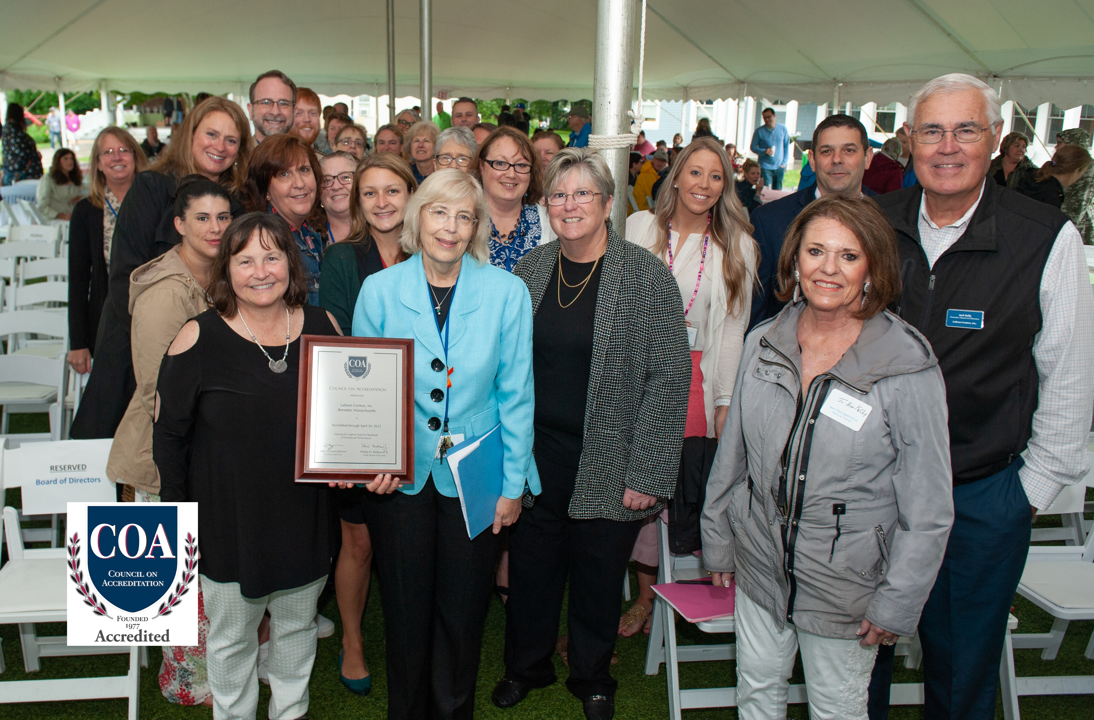 Latham staff, family, and friends hold up COA plaque at End of Year Celebration