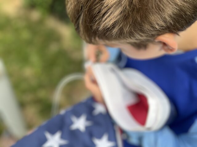 Student putting up flag on flag pole