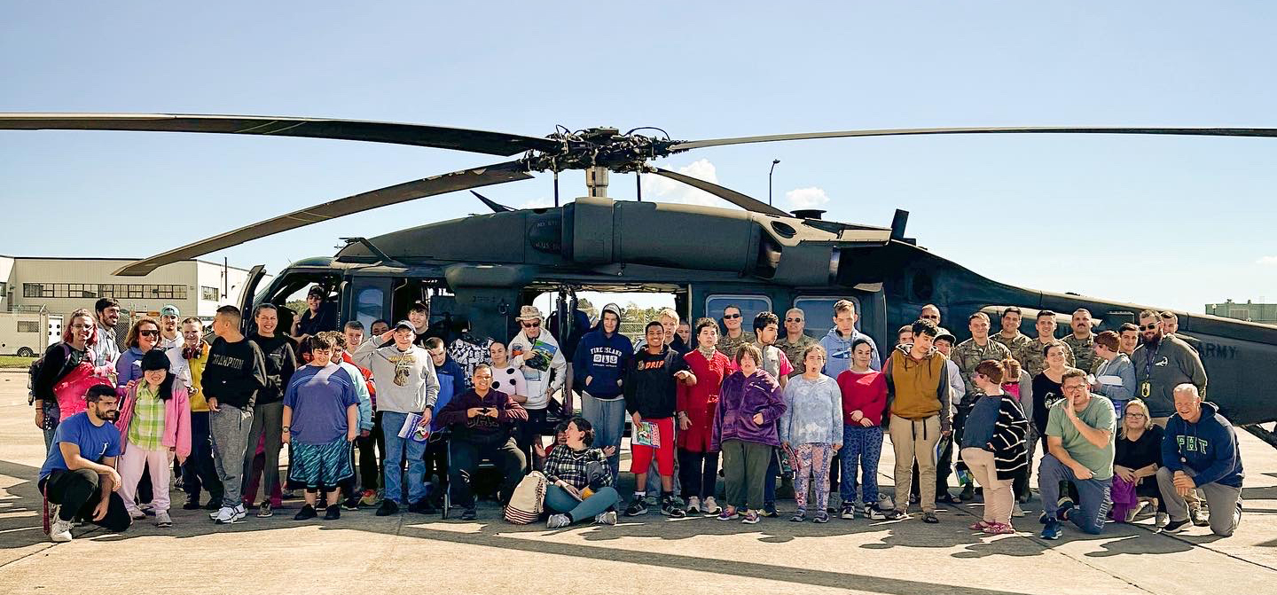 Large Group Picture of individuals in front a helicopter.