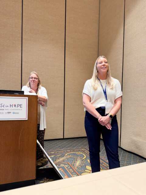 Two women standing at the front of a room.