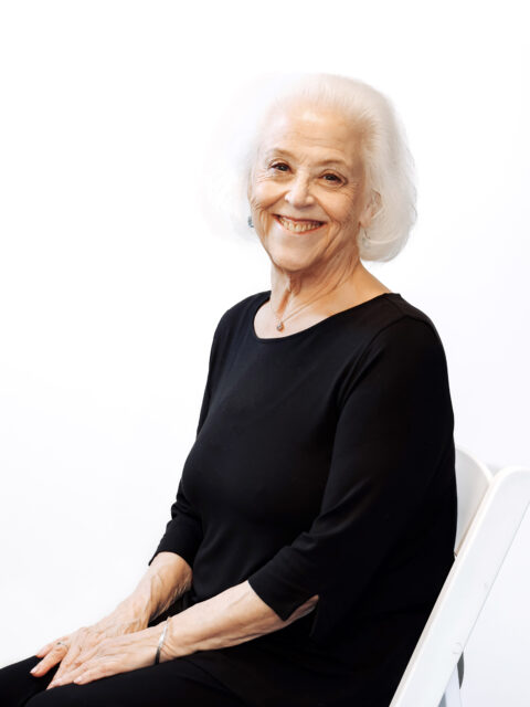 Woman in chair wearing black shirt.