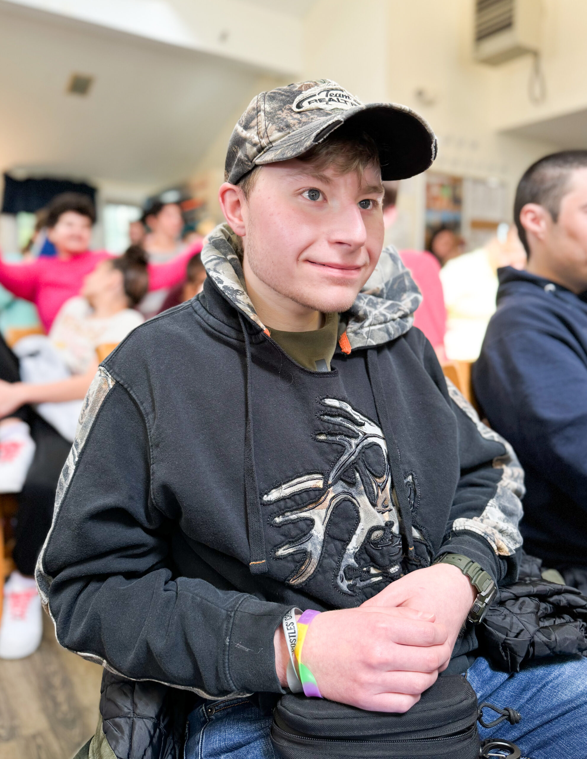 Young man wearing a hat smiling.