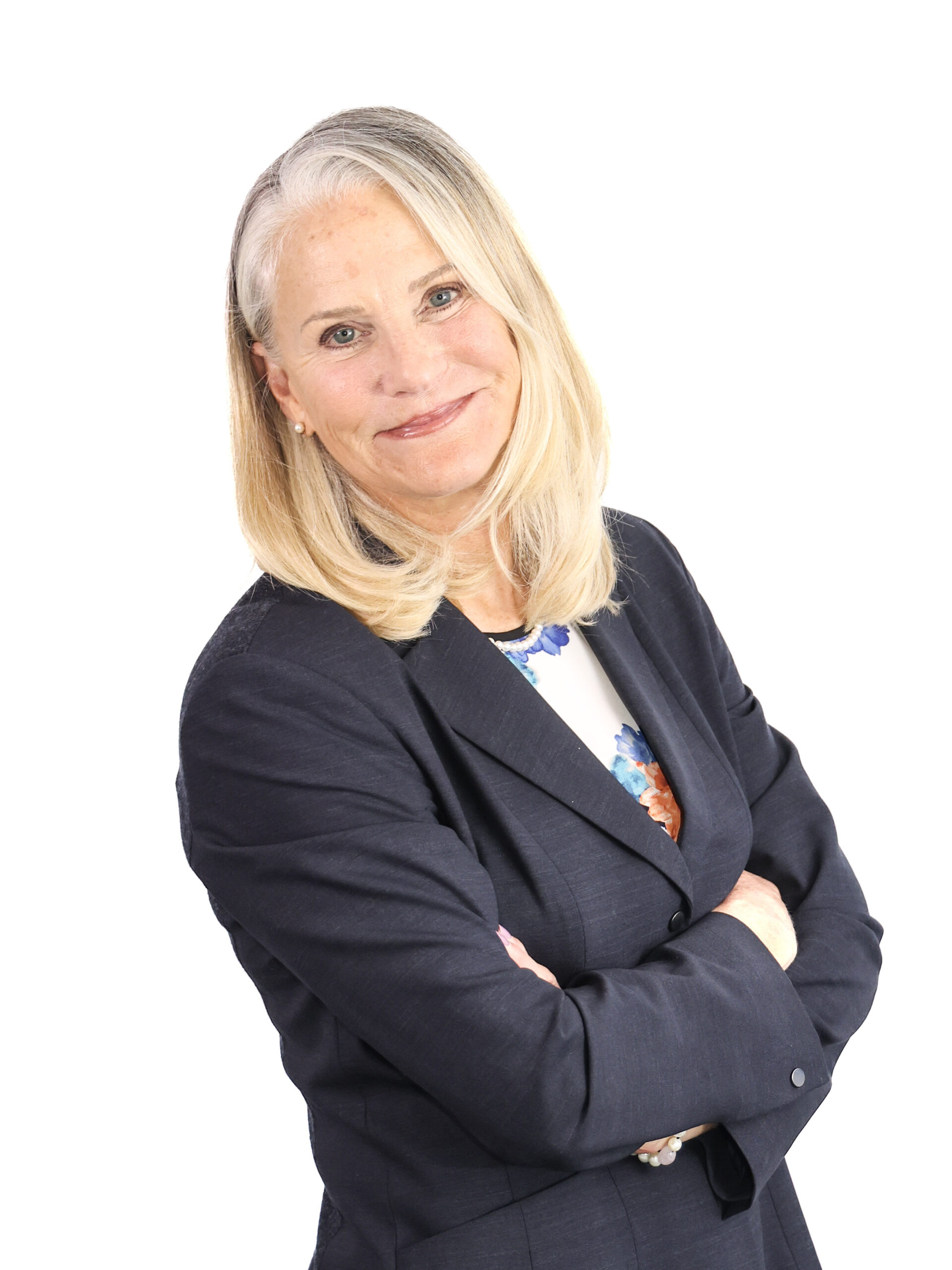 Woman wearing dark suit jacket, smiling. Formal