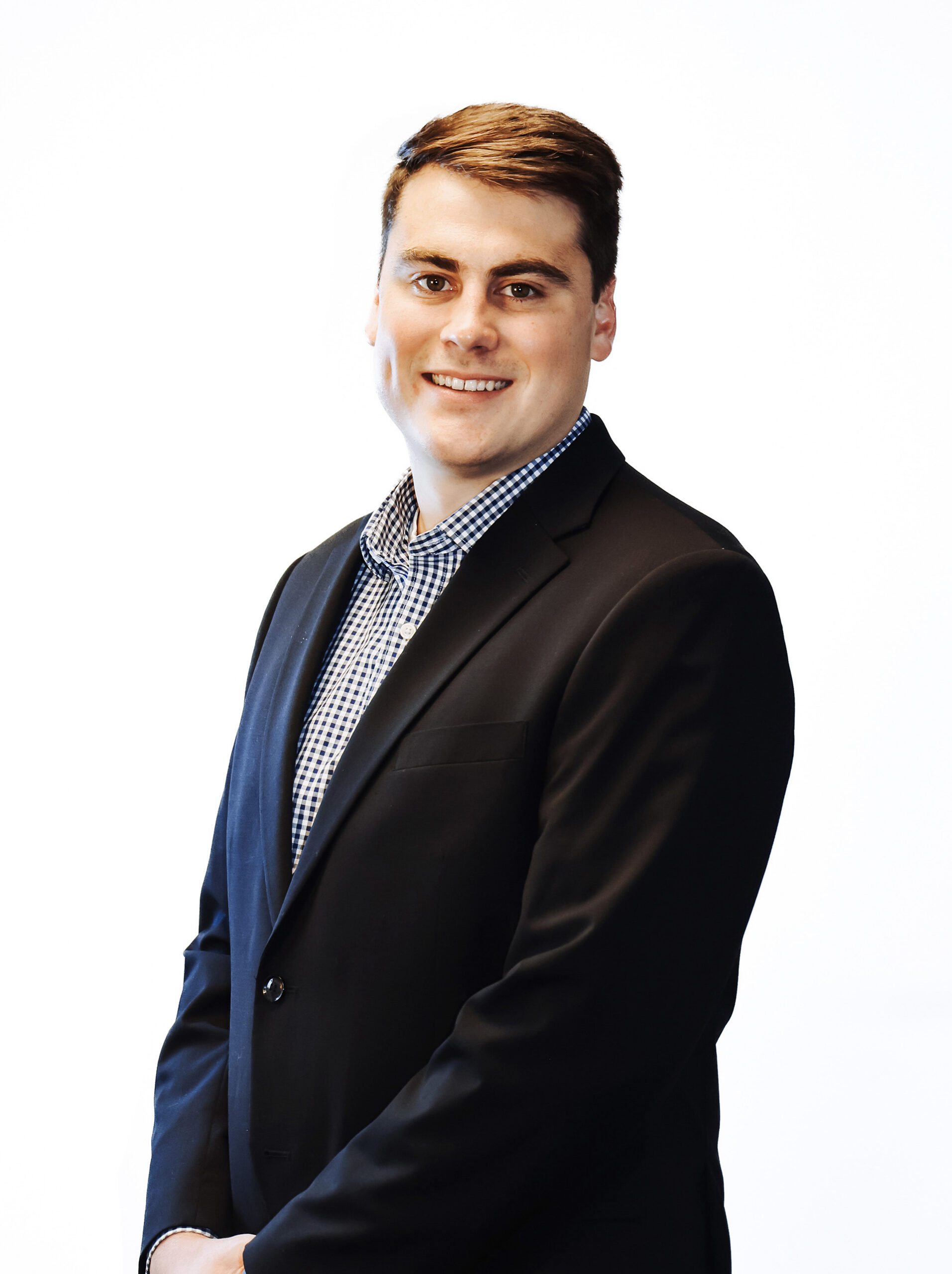 Man standing in a suit with a white backdrop